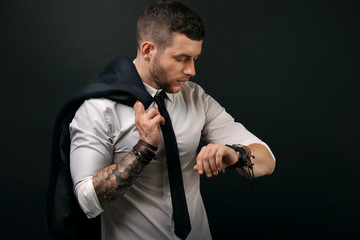 Fototapeta na wymiar Young tattooed man posing on dark background
