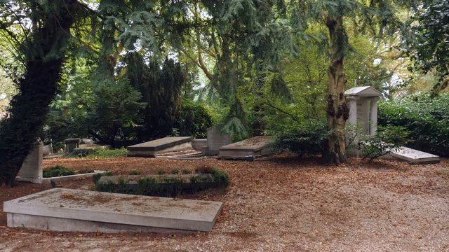 Old graves in small, shaded graveyard.