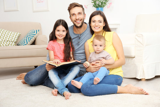 Happy family reading book at home