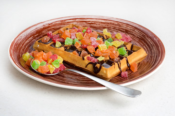 Plate of belgian waffles with cream, candied and chocolate
