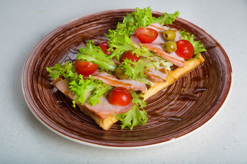 Plate of belgian waffles with ham, tomatoes, herbs and balsamic vinegar