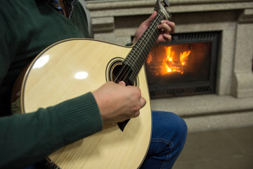 Tocando guitarra portuguesa junto a chimenea