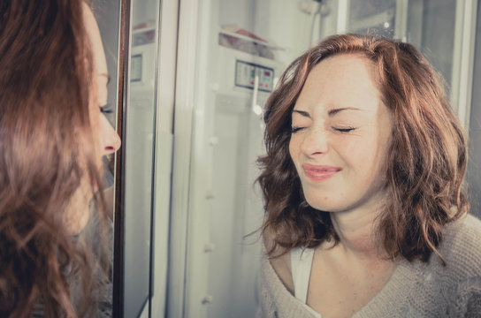 Girl making grimaces in front of the mirror