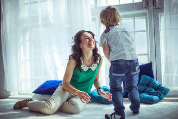 little cute boy and his mother playing together