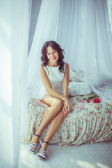 Fototapeta premium beautiful and gentle young woman sits on bed