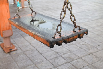 Old wooden swing in playground, close up