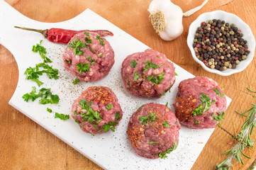 Raw meatballs ready for frying on a tray