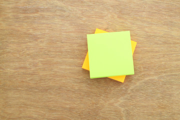 Stack of paper notes (white & yellow) on wood background, selective focus