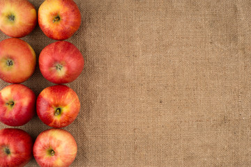Red apples on sackcloth.