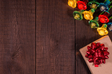 Christmas gifts boxes with garland on a wooden background.