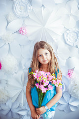 little cute girl holds a bouquet with pink flowers