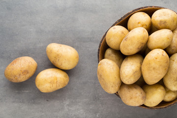 New potato on the bowl, gray background.