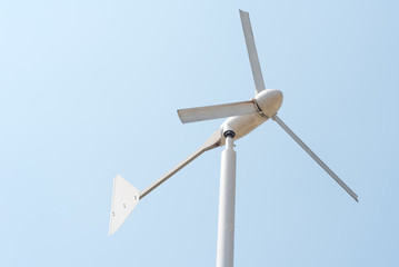 Wind energy turbine power station on clear blue sky