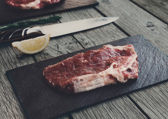 Raw beef steak on dark wooden table background