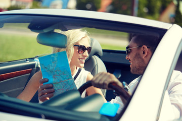 happy man and woman with map in cabriolet car