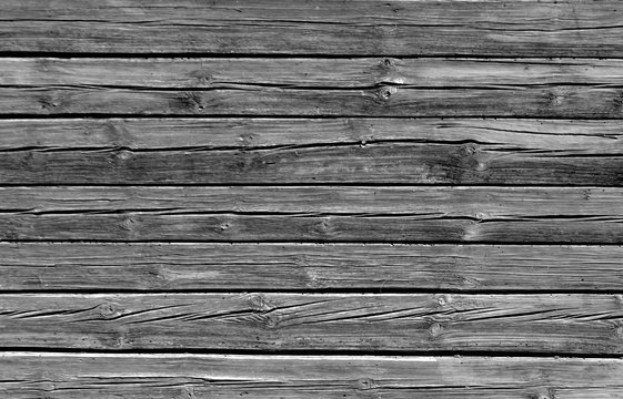 Weathered black and white log house wall.