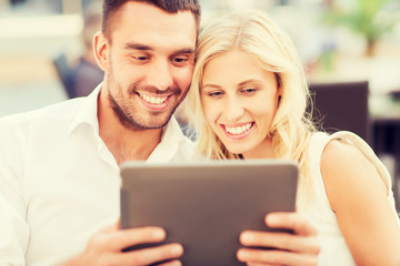 happy couple with tablet pc at restaurant lounge
