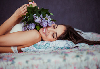 The charming bride with bouquet lie in the bed