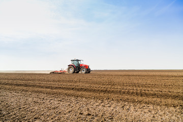 Fototapeta na wymiar Farmer in tractor preparing land with seedbed cultivator