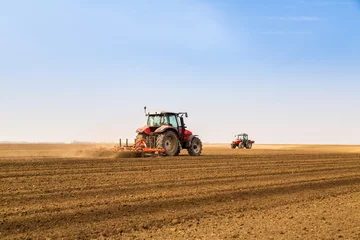 Papier Peint photo Tracteur Farmer in tractor preparing land with seedbed cultivator