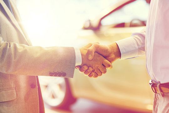 close up of male handshake in auto show or salon