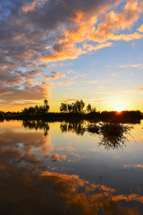 Cumulus sunset clouds with sun setting down