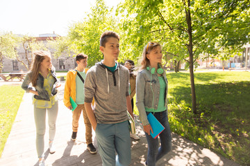 group of happy teenage students walking outdoors