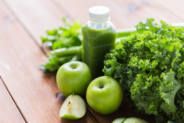 close up of bottle with green juice and vegetables