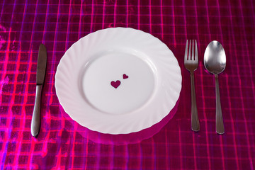 Valentines table setting with silverware and red heart as a decoration