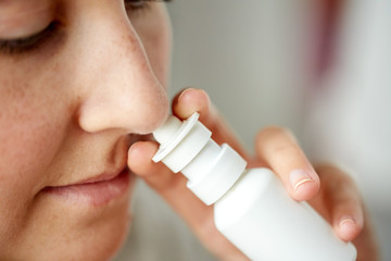close up of sick woman using nasal spray - obrazy, fototapety, plakaty