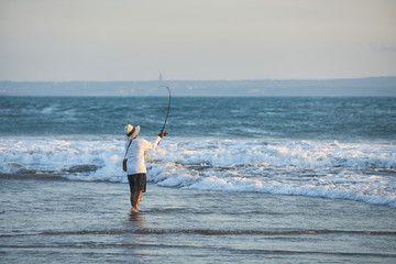 fishing on the beach at sunset