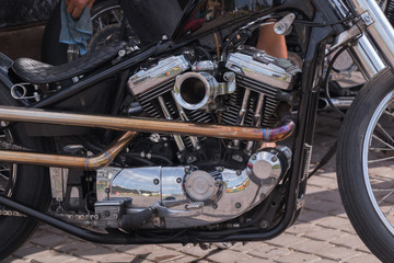 Motorcycle engine close-up. Chrome, shiny parts, wheels, exhaust.