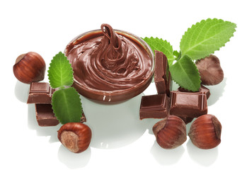 Bowl with chocolate cream, hazelnuts and mint leaves isolated.