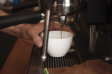 barista close up hands preparing delicious coffee cream operating machine at coffee shop