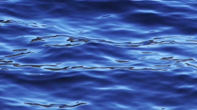 Blue surface of freshwater lake with waves and ripples as abstract natural background