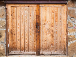 Fototapeta na wymiar Locked wooden gate in stone wall, texture