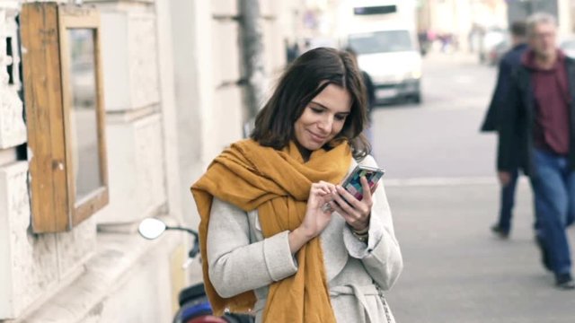 Young beautiful woman texting on smartphone in the city, super slow motion
