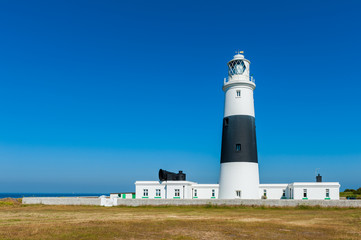 Lighthouse on Alderney, Channel Islands, UK on summer day.