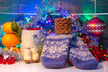 Christmas decoration. christmas red ball, cookies, mug, mandarin, tinsel, lights and mittens