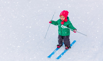 little girl learning to ski in winter