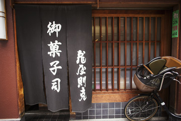 A small artisan producer of specialist treats, sweets called wagashi. Exterior, with a rickshaw bike outside. 