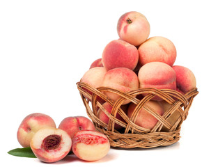 peaches in a wicker basket isolated on white background