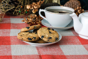 Homemade cookies in a plate on the feast of the new year, christmas. Tasty cookies on a table with a Christmas tree in the background. Tea.