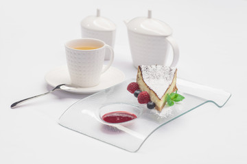 Passion fruit cake, mousse dessert on a white plate with cup of tea.