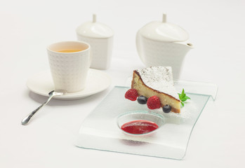Passion fruit cake, mousse dessert on a white plate with cup of tea.