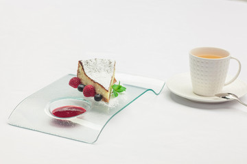 Passion fruit cake, mousse dessert on a white plate with cup of tea.