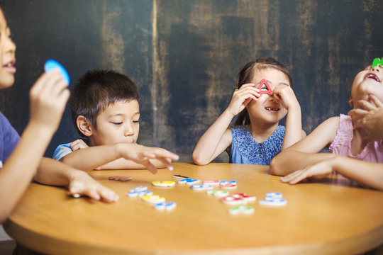  Two boys and two girls holding up alphabet letters