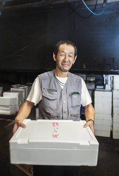 Man Holding Box Of Fresh Fish On Ice