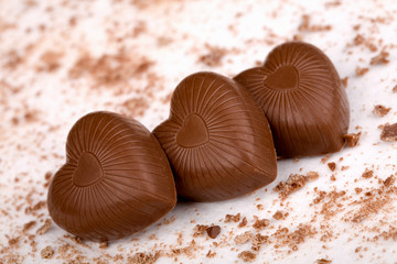 Three chocolate hearts on white background