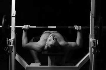 Brutal athletic man pumping up muscles.